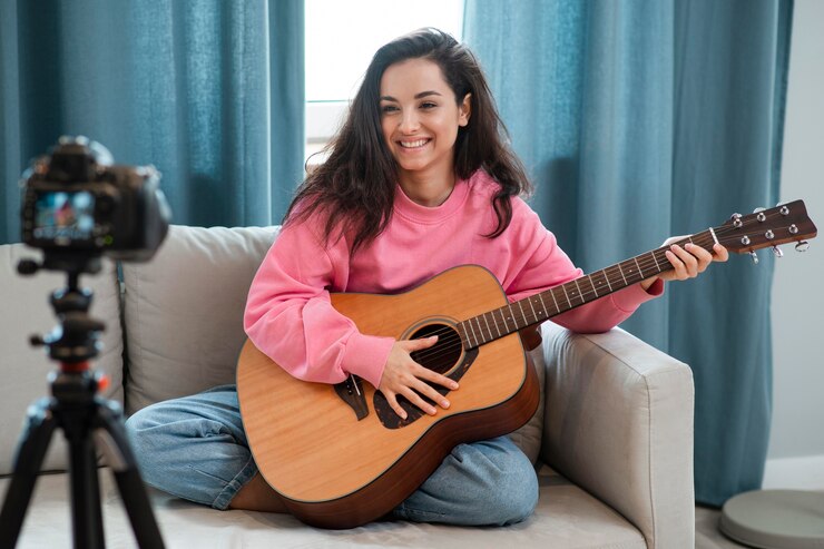 smiley-young-woman-playing-guitar-camera_23-2148538924